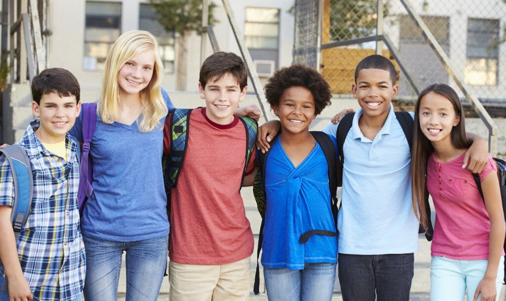 Middle School Kids Wearing Backpacks with their Arms Around Eachother