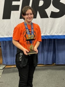 Lacey, holding the First Robotics Impact Award trophy.